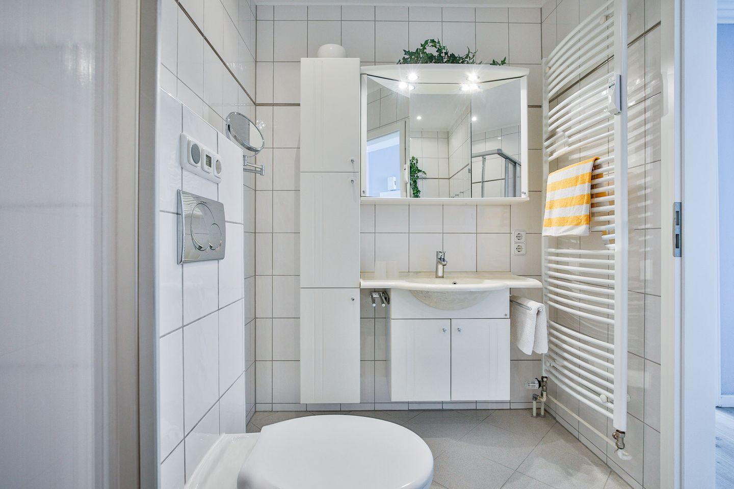 A modern bathroom with a toilet, sink, and shower.