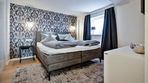 Un dormitorio con cama, mesita de noche y cómoda.