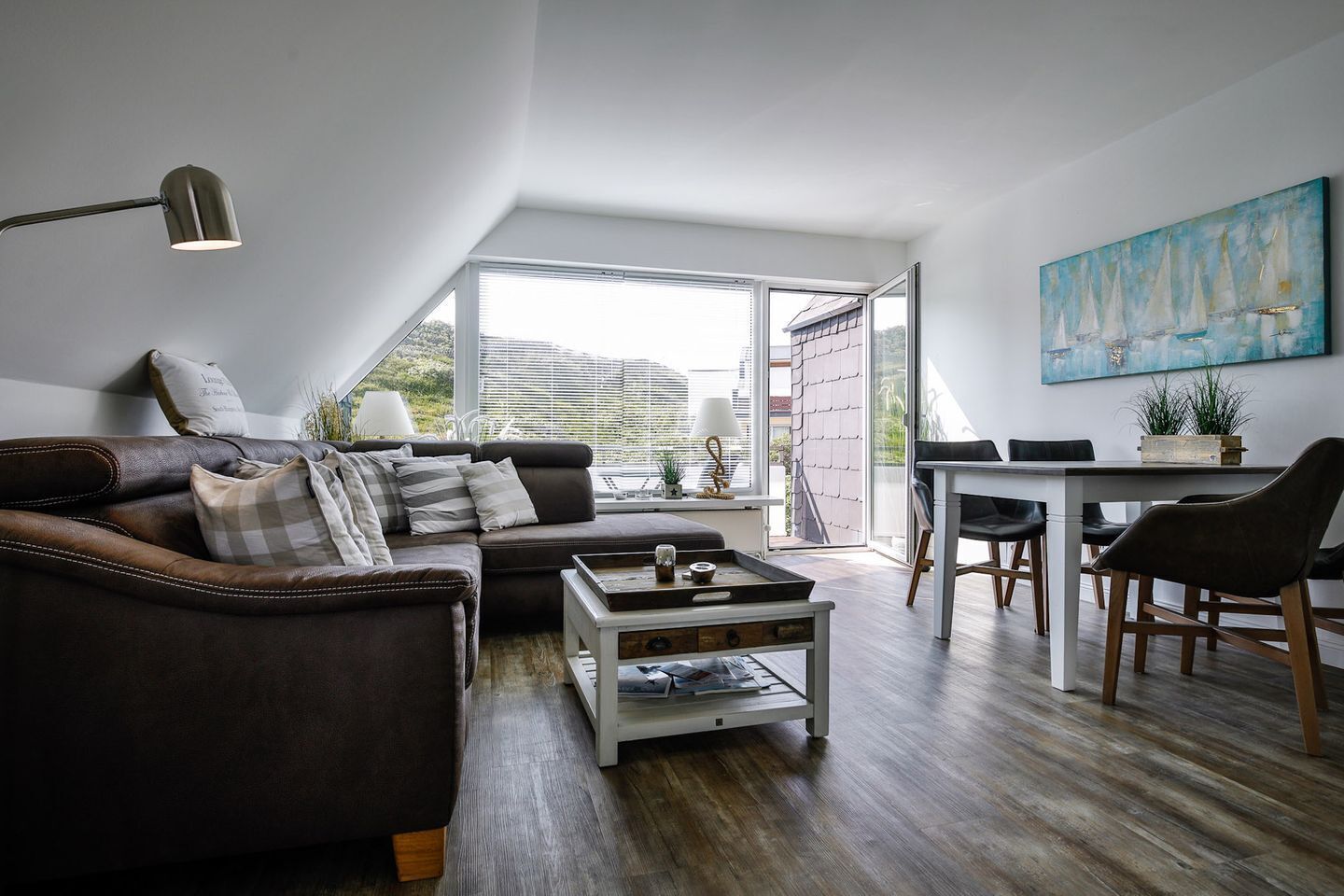 Uma sala de estar moderna com um sofá de couro, uma mesa de centro e um espaço de jantar com mesa e cadeiras.