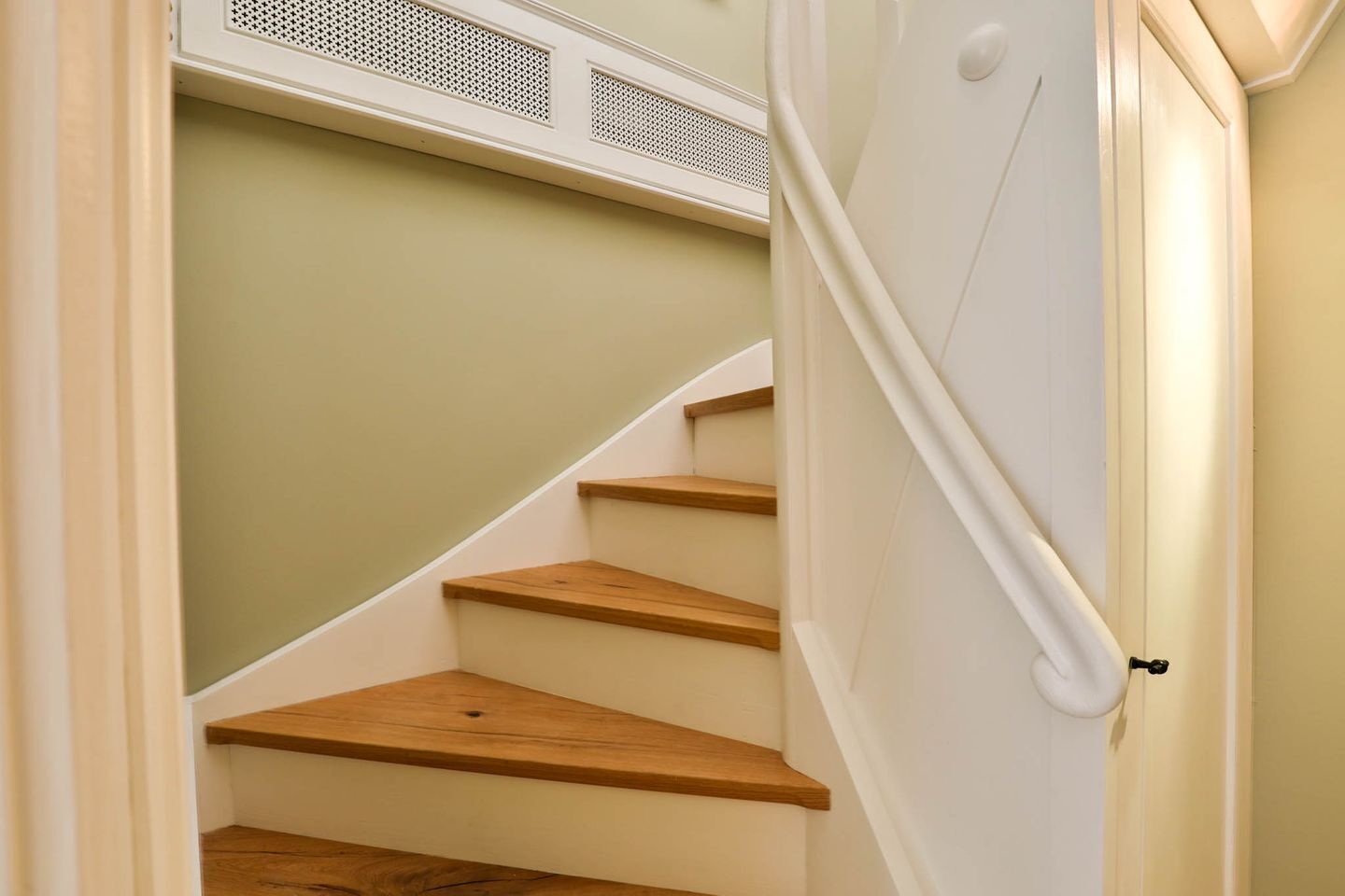 Eine Treppe mit Holzdielen und weißen Wänden.