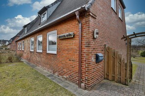A brick building with a sign reading "Pyrckhof 5". - Plyck-Hüs - Beautiful vacation home with a fenced-in yard, near the beach in (Hörnum (Sylt))