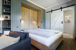 A modern bedroom with a bed, a sofa, and a wardrobe.