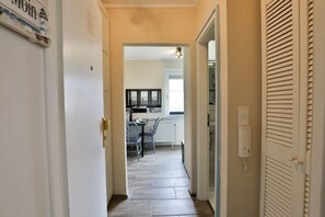 A hallway leading to a kitchen with a dining area.