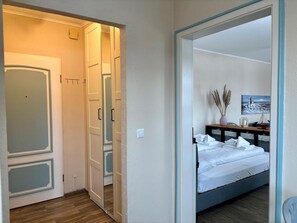 A bedroom with a bed, bedside table, and a painting on the wall. - Charming studio apartment with a balcony, near the beach. - Berlin Ring Road (Hörnum (Sylt))