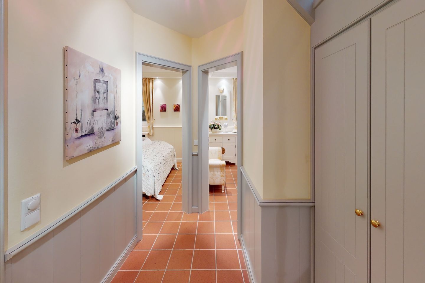Ein Flur mit einem Bett, einem Badezimmer und einer Tür.