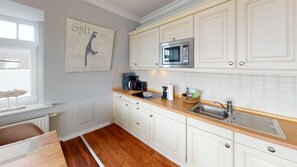 Een koelkast, een magnetron, een kookplaat, een vaatwasser