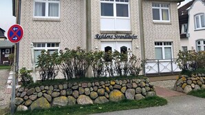 A multi-story residential building with a brick facade and a sign indicating 'Residenz Strandhäuser'.