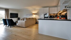 A modern apartment with a living area, kitchen, and dining space. - Lornsendüne - Modern apartment in an absolutely beachfront location in Westerland with (Sylt)