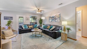 A living room with a sectional sofa, a glass coffee table, and a ceiling fan. - Lake Palo Pinto Home w/ Dock: 22 Mi to State Park! (Palo Pinto)