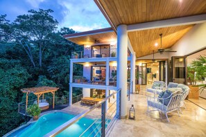 A modern house with a pool, outdoor seating, and a covered patio. - Casa Anjali (Quepos)