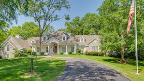 A large, two-story house with a stone facade, a front porch, and a flagpole. - Pool, Hot Tub & Outdoor Theater: Franklin Retreat (Franklin)