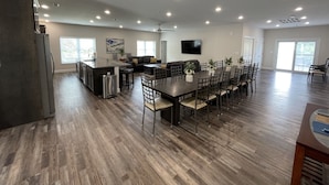 Uma sala de estar ampla com cozinha, mesa de jantar e assentos.
