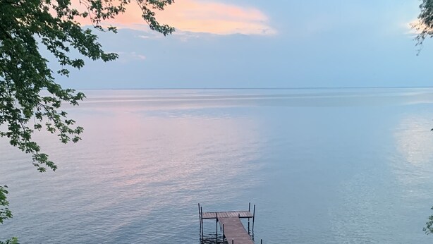 Eine Holztreppe führt zu einem Steg über ruhigem Wasser.