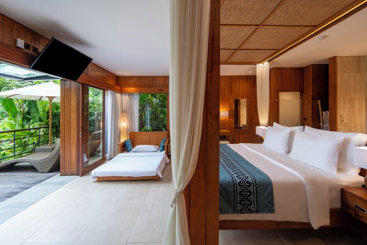 Un dormitorio con una cama grande, un televisor montado en la pared y vistas al exterior.