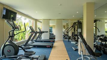 A gym with treadmills, elliptical machines, and weight equipment.