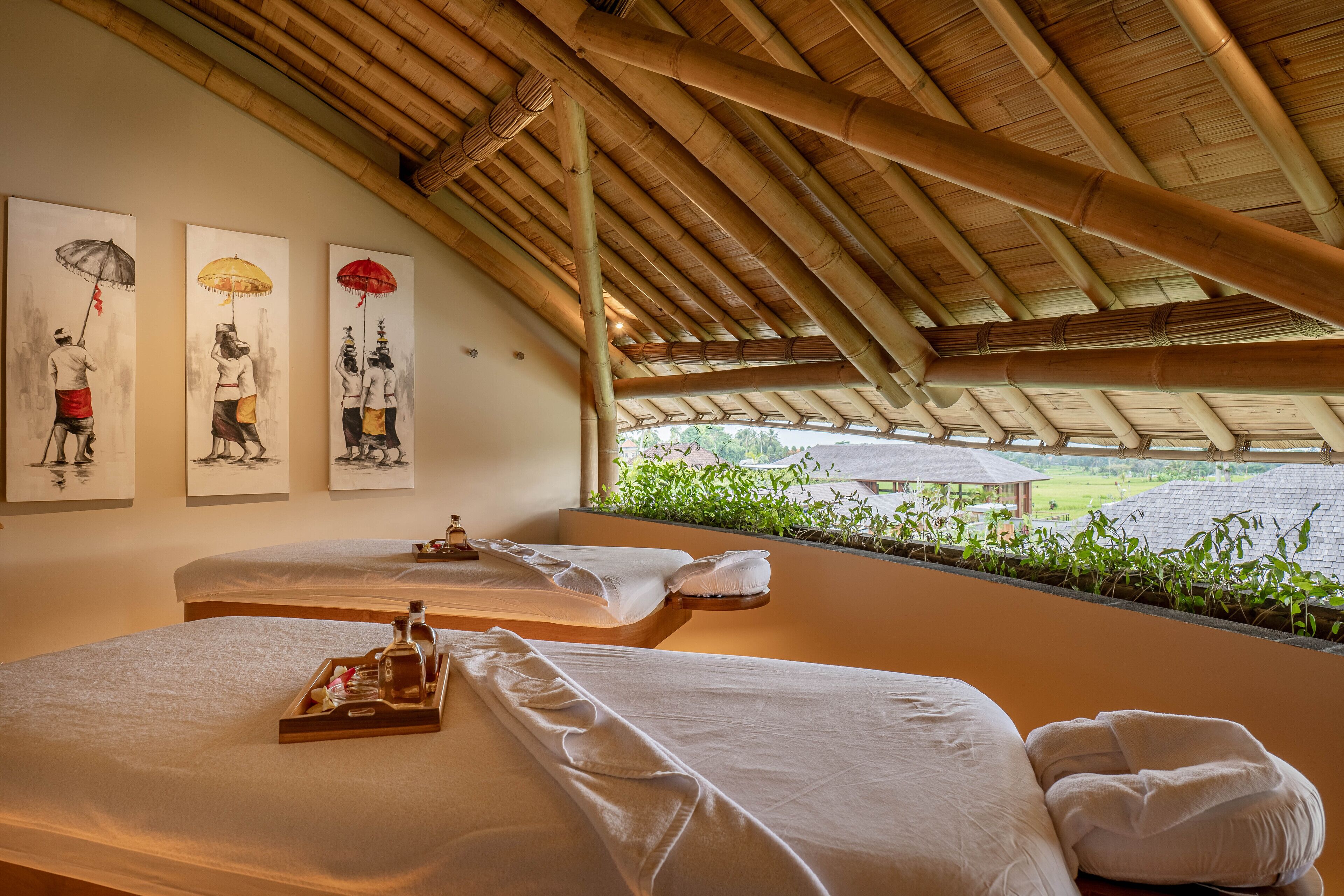 A room with two beds, a tray with toiletries, and artwork on the wall.