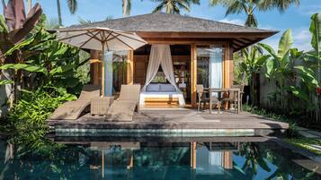 A wooden villa with a pool, a bed, and a dining area.