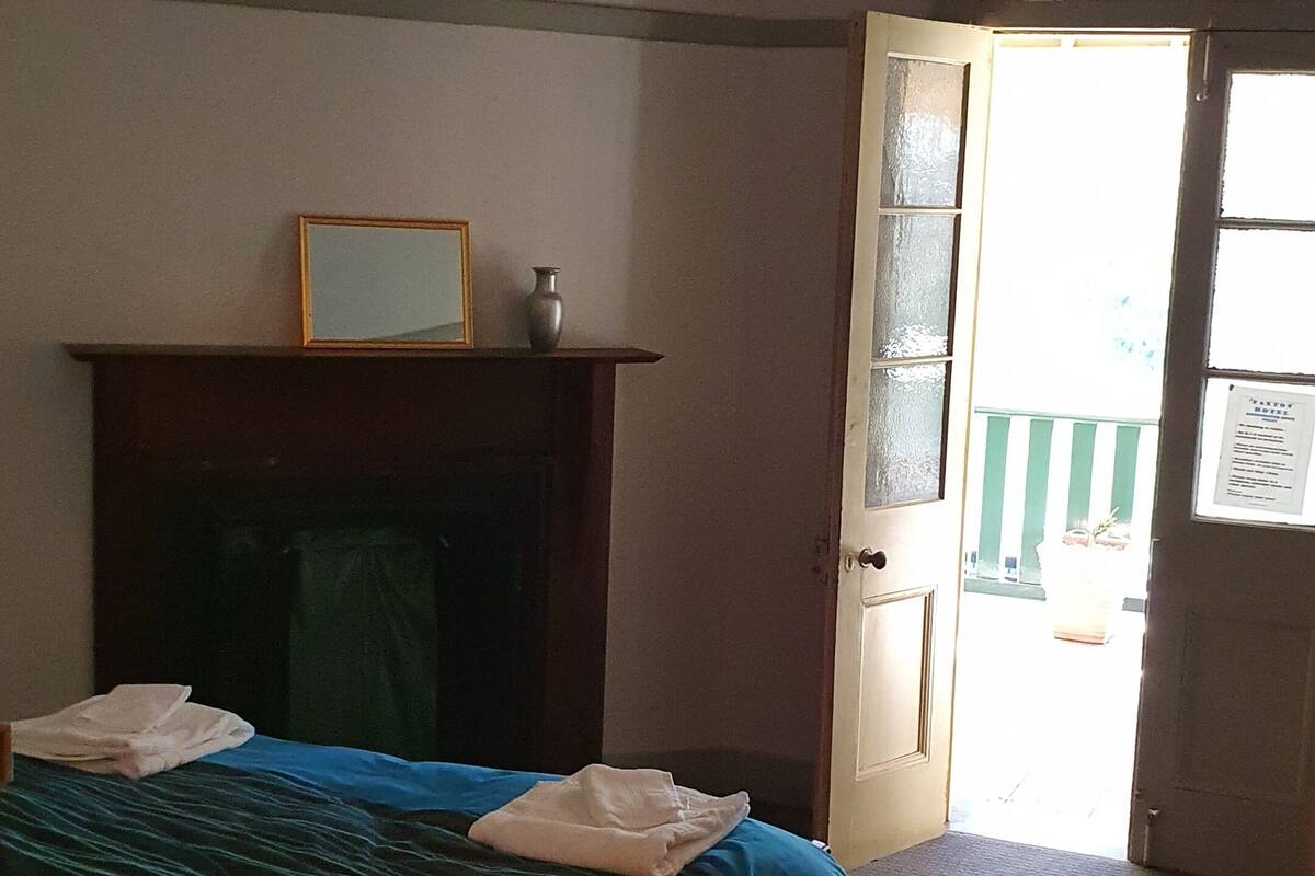 Un dormitorio con cama, chimenea y puerta que da al exterior.