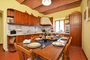 A dining area with a wooden table set for four, surrounded by wooden chairs. - Certosa 4, Firenze, Italy (Firenze)