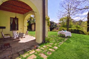 A covered patio with outdoor seating, a lawn, and a table set for dining. - Certosa 4, Firenze, Italy (Firenze)