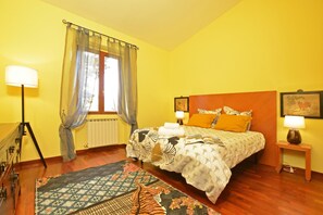 A bedroom with a bed, bedside lamps, a window with curtains, a radiator, and a patterned rug. - Certosa 4, Firenze, Italy (Firenze)
