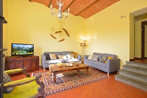 A living room with a television, two sofas, a coffee table, and a patterned rug. - Certosa 4, Firenze, Italy (Firenze)