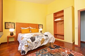 A bedroom with a bed, bedside tables, a nightstand, a wardrobe, and a patterned rug. - Certosa 4, Firenze, Italy (Firenze)