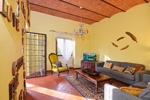 A living room with a sofa, armchair, TV, and decorative wall art. - Certosa 4, Firenze, Italy (Firenze)