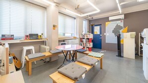A modern office space with a round table, multiple chairs, a bookshelf, and a map on the wall.