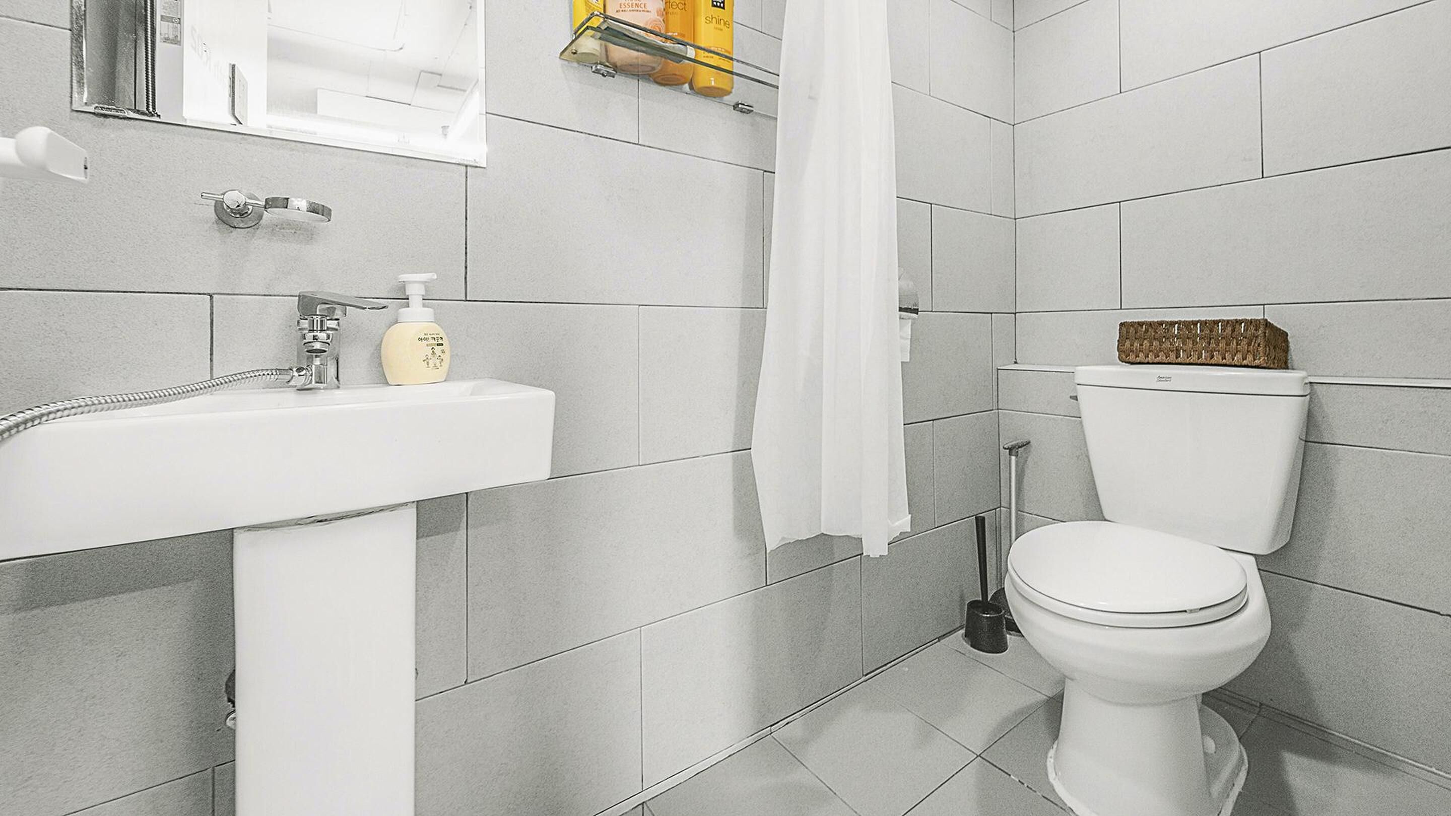 Een badkamer met een witte wastafel, toilet en douchegordijn.