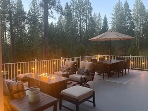 An outdoor patio with a fire pit, seating, and an umbrella. - Rozoff Retreat (Groveland)