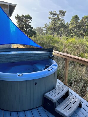 A hot tub on a wooden deck with a blue shade sail and steps leading up to it. - Pacific City Charmer - 2 blocks from beach! (Pacific City)
