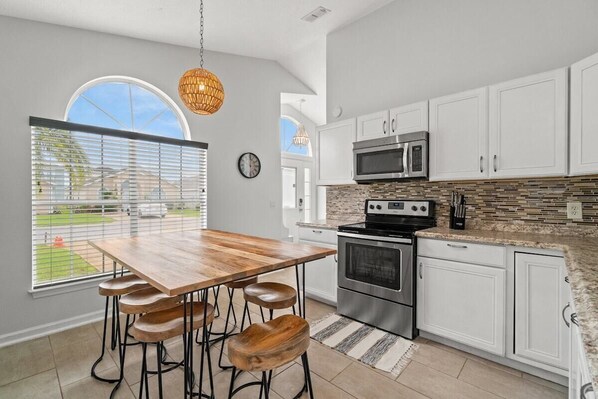 Enjoy meals in this kitchen with a stainless steel oven, microwave, and dining area with a view.