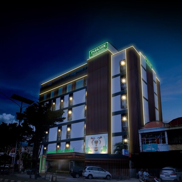 Een hotel met meerdere verdiepingen, met een opvallend bord waarop 'Parkside Star Hotel' staat.