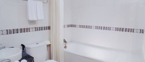 A modern bathroom with a toilet, sink, and bathtub.