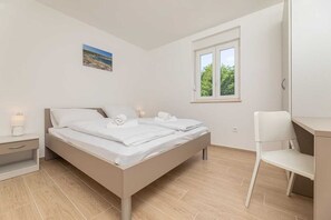A bedroom with a bed, bedside table, chair, and a window with a view. - Apartment Sucic Tea 5 (Soline - island Krk)