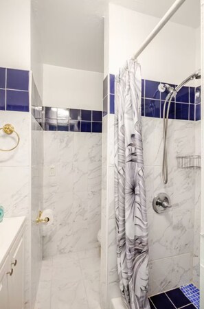 Tina con regadera, secadora de cabello, toallas 