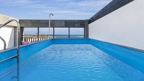 A swimming pool with a view of the beach and ocean.
