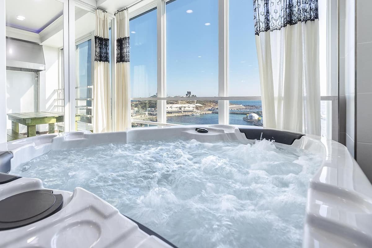 A hot tub with a view of a coastal area.