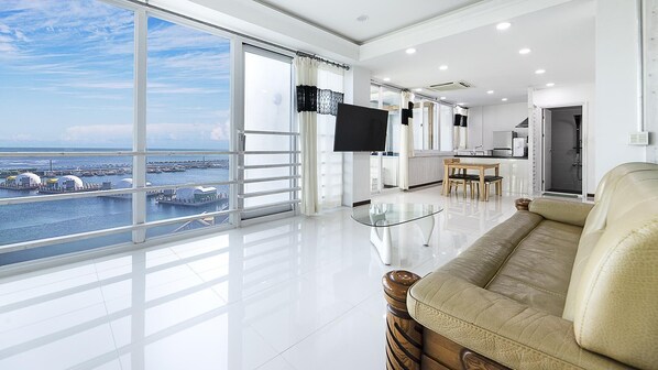 A spacious living area with a large window offering a view of a marina.