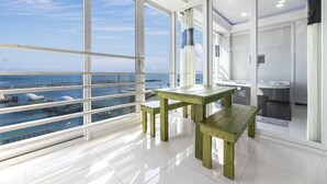 A modern room with large windows, a wooden table, and a view of the sea. - Pohang 0.1 Poolvilla (Pohang)