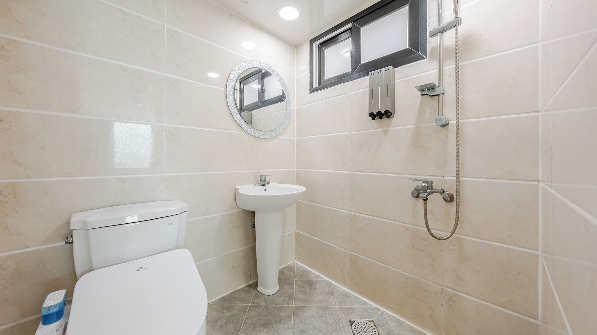 A bathroom with a toilet, sink, and shower.
