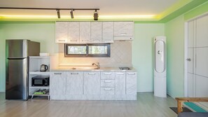 Een moderne keuken met een inbouwoven, een magnetron en een koelkast.