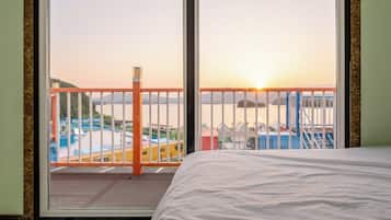 A hotel room with a large window, a bed, and a view of a water park.