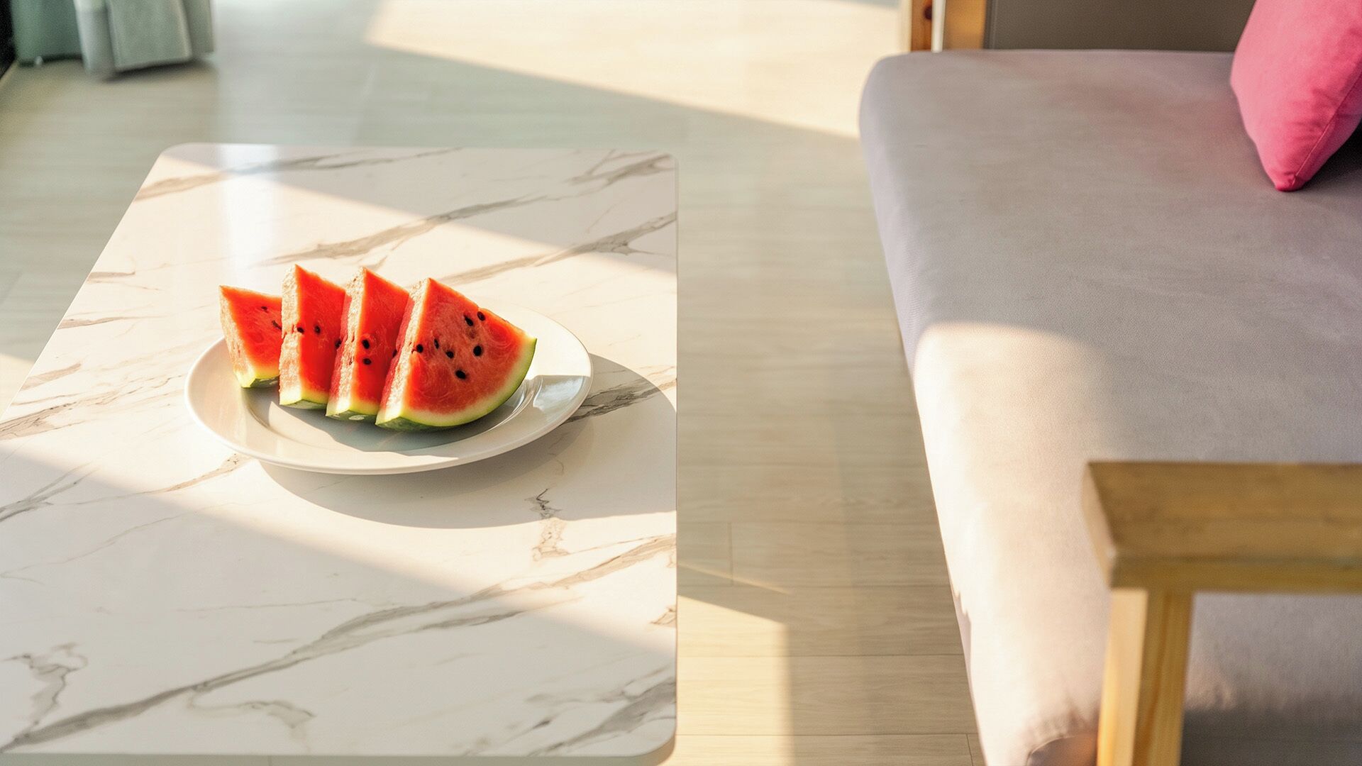 A marble table with a plate of watermelon slices.