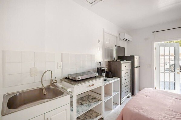 A compact kitchen with a sink, microwave, and a small countertop.
