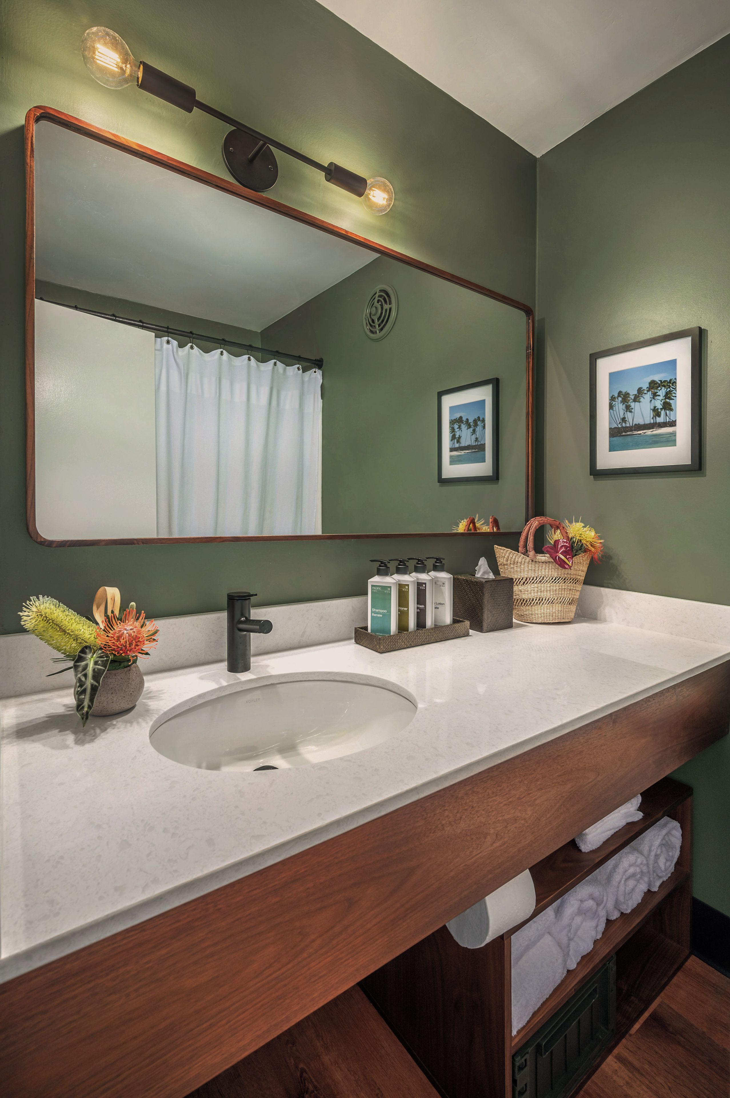 A bathroom with a large mirror, a sink, and a vanity area.