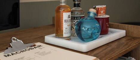 A wooden table with a white tray holding various bottles, a clipboard with a menu, and a red mug.
