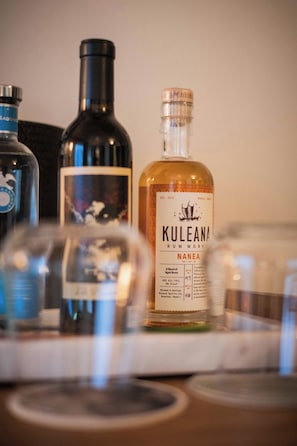 A bottle of Kuleana Rum with a label, a bottle of another spirit, and a glass in the foreground. - PACIFIC 19 Kona (Kailua-Kona)