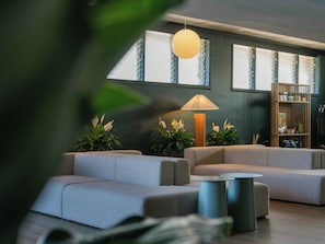 A modern living room with grey sofas, a round table, and a floor lamp. - PACIFIC 19 Kona (Kailua-Kona)